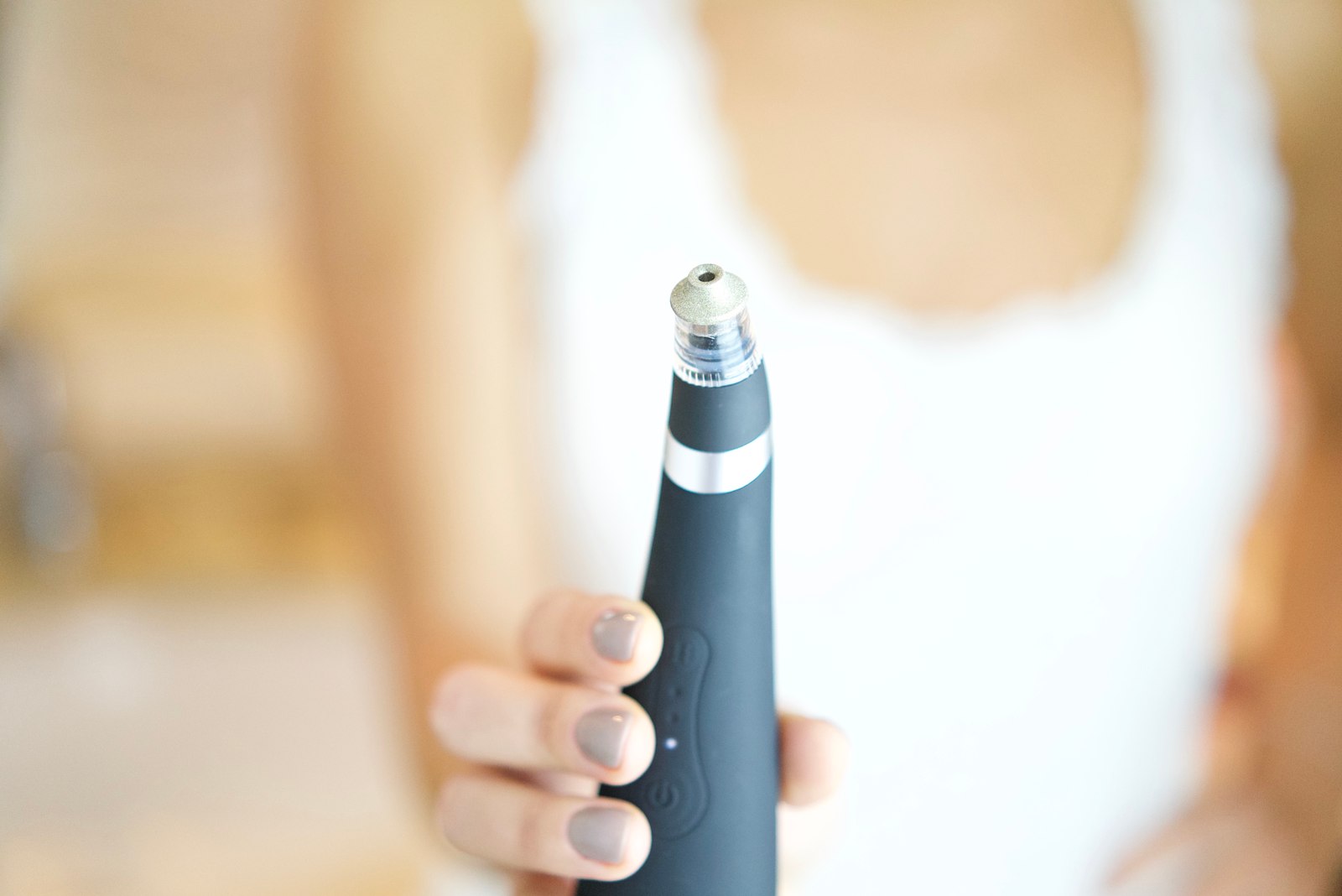 Hand holding a Mantra microdermabrasion device tip