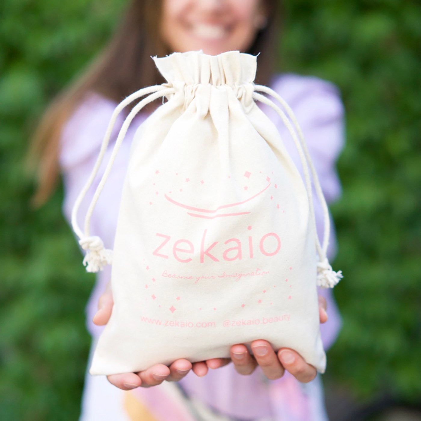Smiling woman holding out a Zekaio drawstring pouch