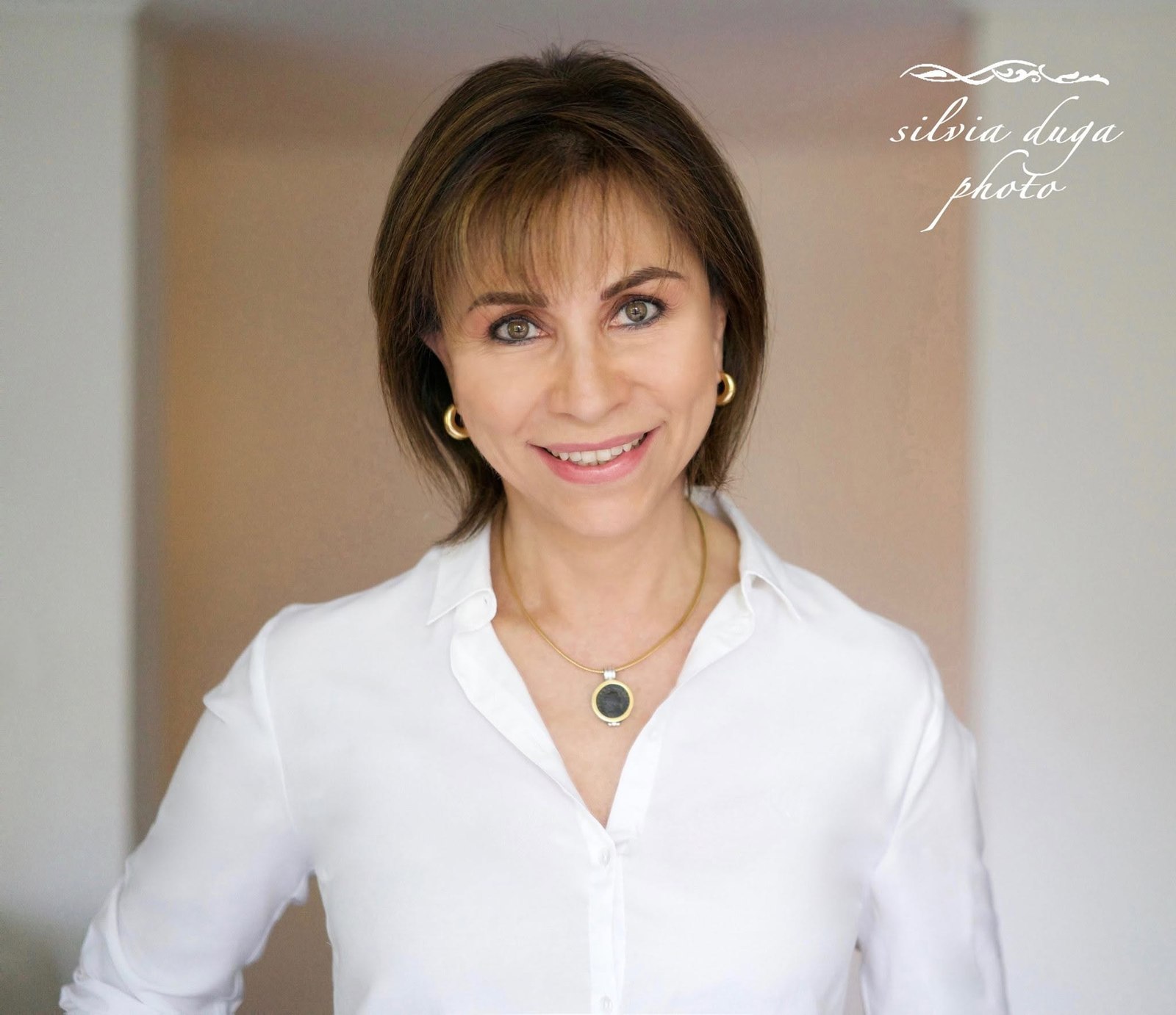 Corporate headshot of a smiling woman in a white blouse