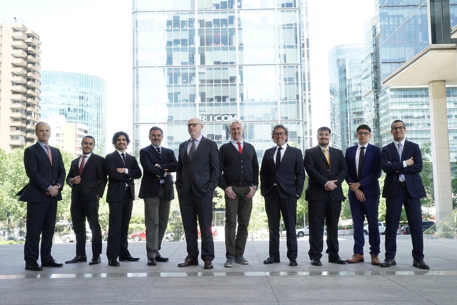 Group of colleagues from 555 Abogados standing outdoors among city office towers