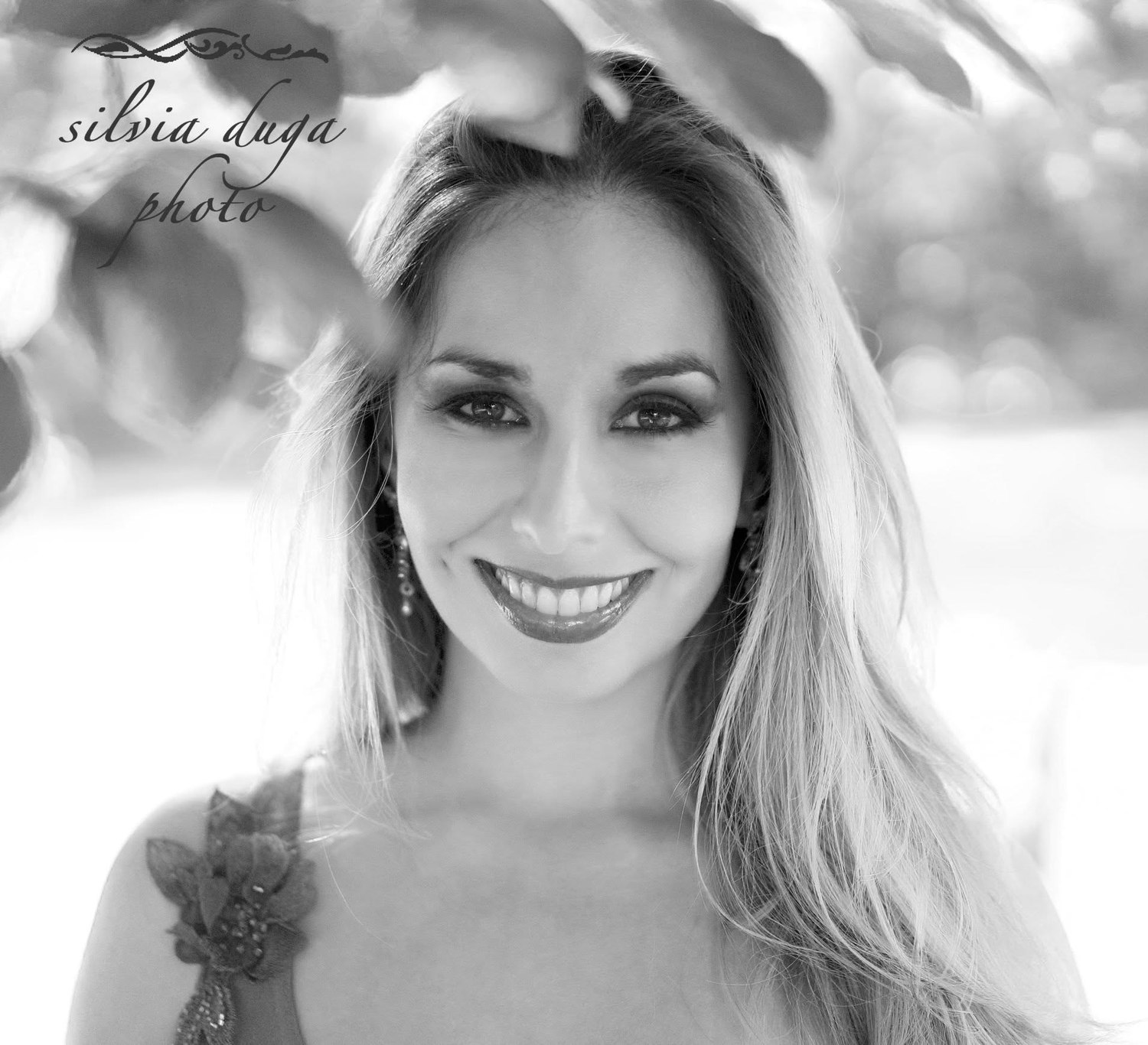 Black and white portrait with dramatic natural light through leaves