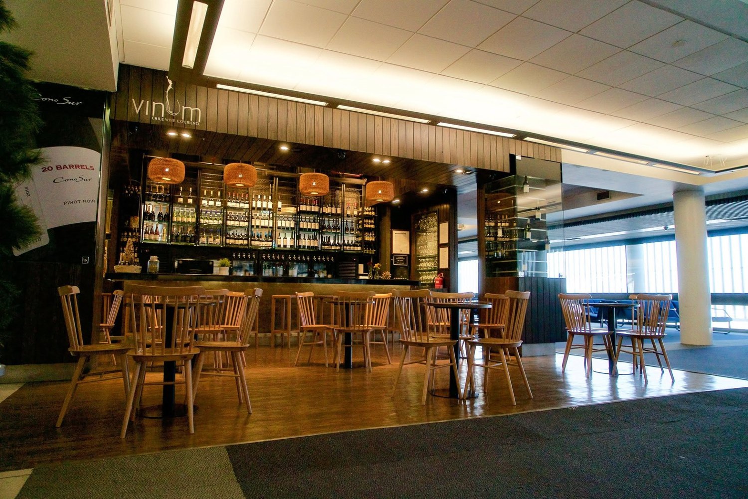 Interior of the Vinum wine bar with wooden tables and a wall of wine bottles